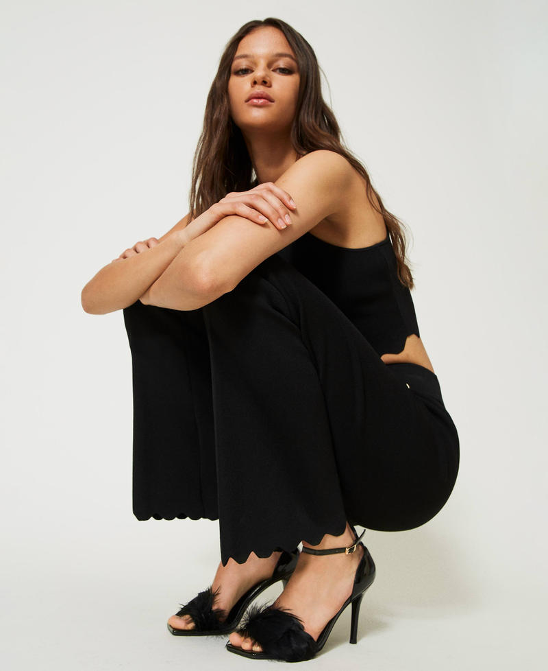 Pantaloni flare in maglia con fondi smerlati