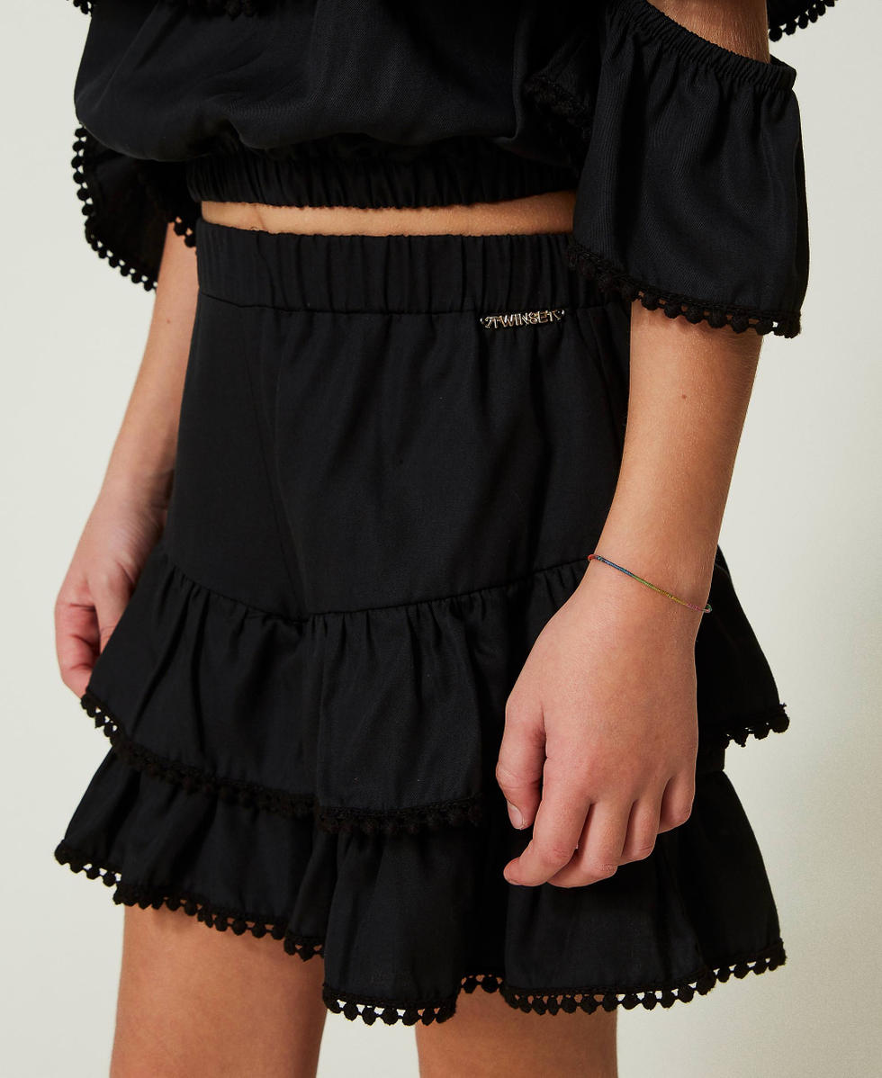 Shorts con balze e pompon